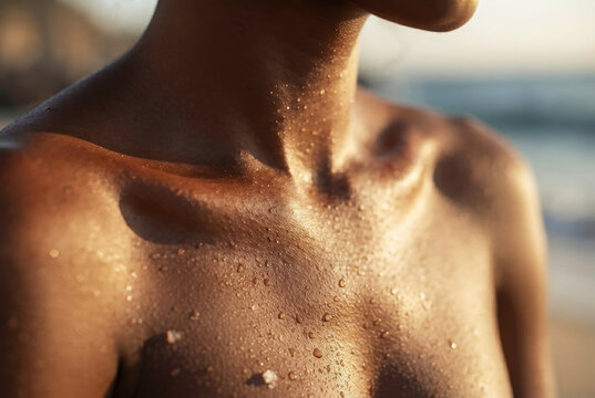 Close up of woman chest and collarbone covered in water drops outdoors at sunset
