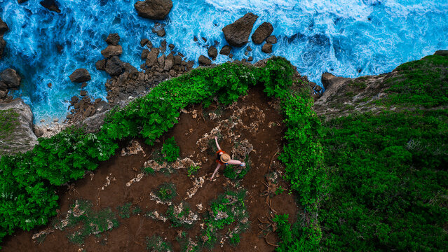 Girl standing on Karang Boma cliff, Bali, Bukit. Aerial top down view