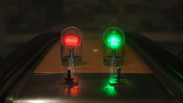Two modern signal lights with a green arrow and an off light in a dim setting. Concept of technology, innovation, and urban design, ideal for marketing and editorial uses.