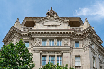 Upward view of the ornate neoclassical corner tower and pediment of the Hungarian National Bank building in Budapest, Hungary © GuillaumeAngleraud