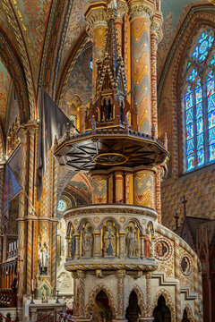 Ornate carved Gothic Revival pulpit lined with statues of saints inside Matthias Church in Budapest, Hungary