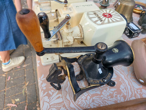 Xalo, Spain - June 20, 2026.Old mechanical cast iron Spong coffee bean grinder on a table at a vintage market with other items