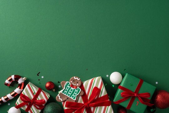 Merry Christmas and Happy New Year gift arrangement with gingerbread cookie and ornaments on green background