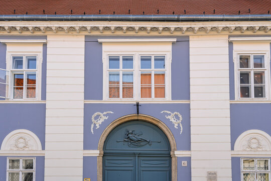 Blue and white baroque facade of a historic house with a carved lunette in the Buda Castle district of Budapest, Hungary