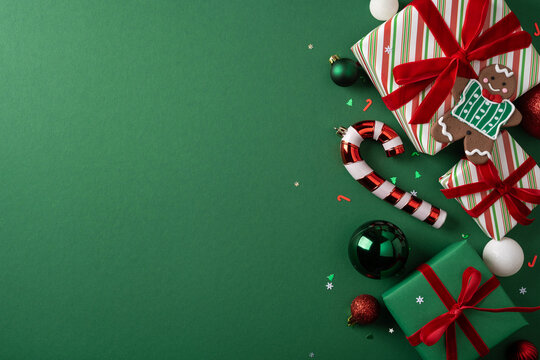 Merry Christmas wrapped gifts with candy cane gingerbread cookie and ornaments on green background