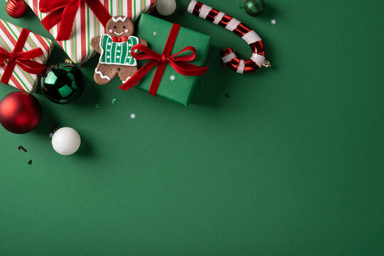 Christmas present with gingerbread cookie, ribbon bow and ornament on green background for Merry Christmas and Happy New Year