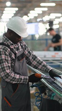 African american factory worker assembling window frames