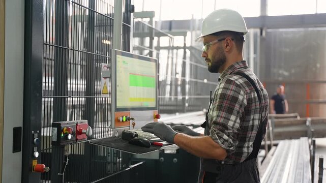 Factory engineer operating industrial computer machinery