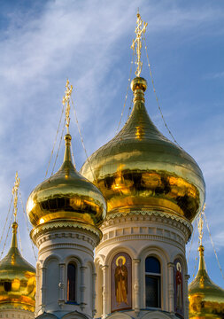 Gilded domes of an Orthodox church against a blue sky. Close-up. Religious concept. Vertical composition.