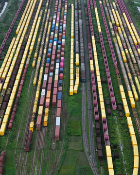 Aerial view of the Chattogram Port train yard featuring rows of colorful cargo containers on rail cars with green vegetation between tracks in Chittagong, Chittagong Division, Bangladesh.