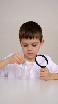 Laboratory examination of a child with test tubes, reagents and a microscope. Selective focus.