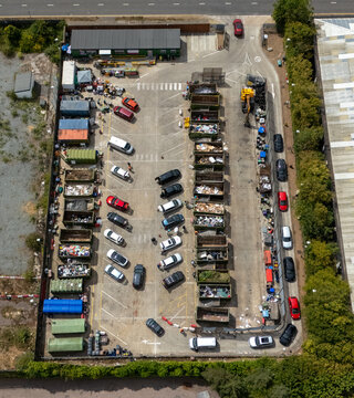 Aerial view of Stevenage Recycling Centre with rows of waste containers, parked vehicles, and industrial facility infrastructure, Stevenage, England, United Kingdom.