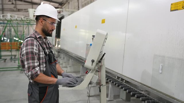 Factory worker operating glass cutting machine
