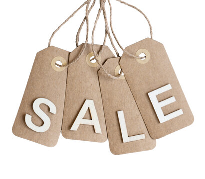 Four brown kraft paper tags hanging by twine with white wooden letters spelling SALE isolated cutout on transparent background
