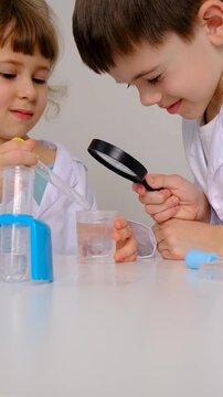 Laboratory examination of a child with test tubes, reagents and a microscope. Selective focus.