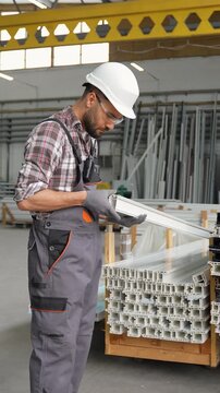 Factory worker checking quality of plastic profile