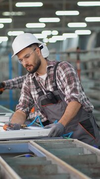 Factory workers assembling plastic windows on production line