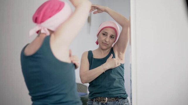 Woman with cancer examining her breast surgery scar