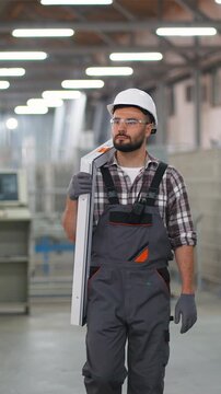 Factory worker carrying aluminum window profile