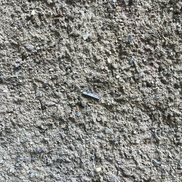 Close up of rough concrete wall texture with gravel surface