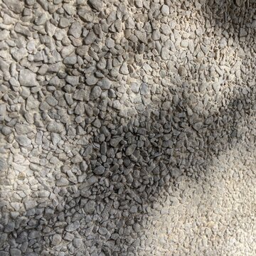 Exposed aggregate concrete texture with pebble stones and shadow