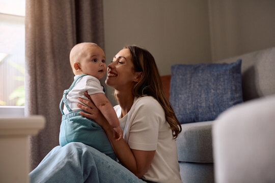 Happy mother enjoying in time with her baby boy at home.