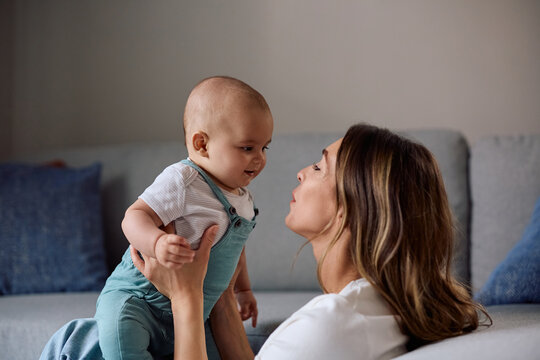Smiling baby boy and his mother spending time together at home.