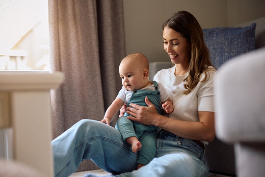 Young happy mother spending day with her baby son at home.