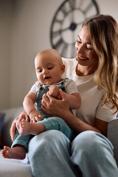 Happy baby boy and his mother enjoying in family time at home.