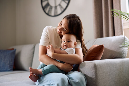 Loving mother embracing her baby son at home.
