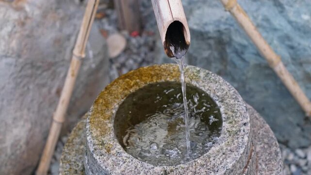 Relaxing water drop dripping from bamboo pipe close up