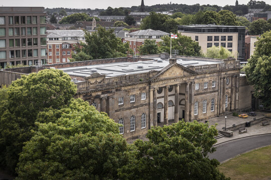 Aerial view of York Castle Museum with its neoclassical architecture, surrounding lush trees, and urban cityscape in York, England, United Kingdom.