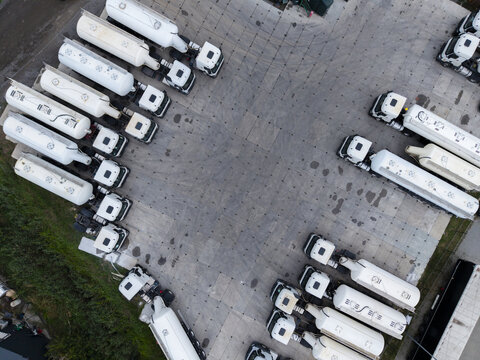 Aerial view of a parking lot filled with white tanker trucks arranged in rows on a paved surface in Krakow, Lesser Poland Voivode, Poland.