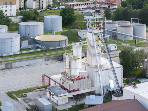 Aerial view of the Wieliczka Salt Mine industrial site featuring a tall mine shaft tower, white silos, and large storage tanks in Wieliczka, Lesser Poland Voivode, Poland.