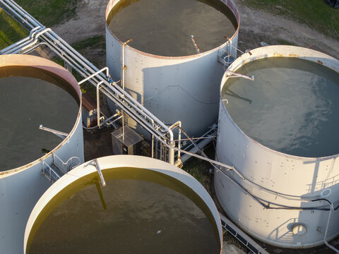 Aerial view of industrial storage tanks at the Wieliczka Salt Mine, with large cylindrical containers and metal piping systems in Wieliczka, Lesser Poland Voivode, Poland.