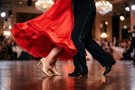 Couple ballroom dancing with woman wearing a long flowing red dress and gold high heels