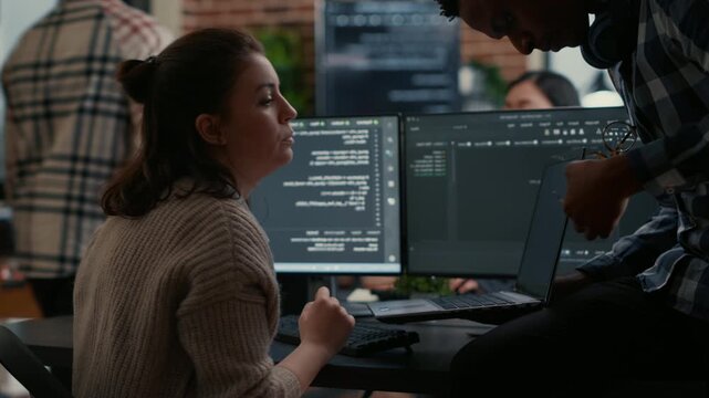 Junior programmer works under senior developer supervision at a multiple screen desk, connecting mentorship, code review and development training, inside a programming agency setting.