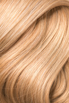 Blond hair background, lock of long straight hair, healthy and beauty dyed hair backdrop design, salon, treatment, cure, dying concept. Close up, top view, vertical photo. 