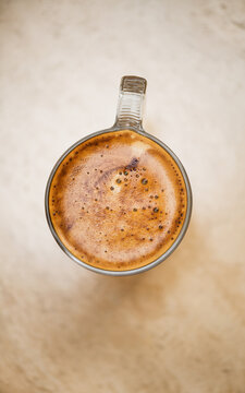 Coffee espresso top view. Cup of Espresso foam texture, creamy coffee, rich, freshly brewed cup of hot latte. Top view of cappuccino milk foam closeup. Creamy coffee macro shot, on a marble table