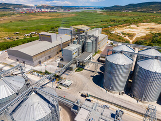 Large industrial facility with silos and machinery in an agricultural area on a clear day © DSMT