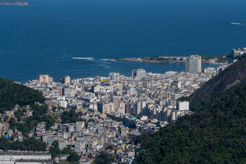 Naklejka premium Copacabana surge entre os morros com mar aberto e prédios alinhados, formando um cenário amplo que destaca a geografia . Rio de Janeiro, Brasil
