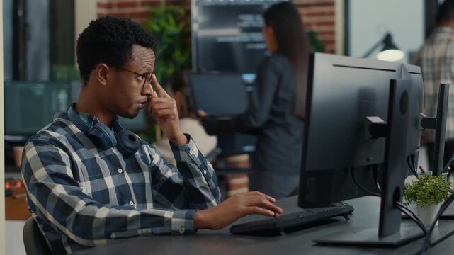 IT startup employee reviews running code while planning a new user interface, blending brainstorming, software architecture and group problem solving, while tracing software problems.