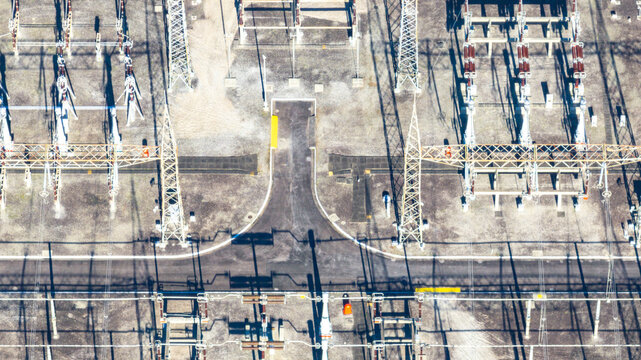 Aerial view of the electrical substation at Nuclear Power Plant Angra 2, with power lines, metal towers, and industrial equipment on gravel ground in Angra dos Reis, Rio de Janeiro, Brazil.