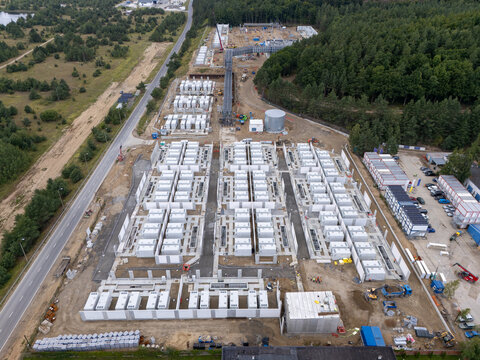 Aerial view of Zarnowiec Pumped Storage Power Plant construction site, featuring rows of white energy storage containers and heavy machinery in Wejherowo County, Pomeranian Voivodeship, Poland.