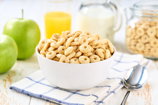 Healthy breakfast with corn rings and fruits and juice on a white wooden table, selective focus.