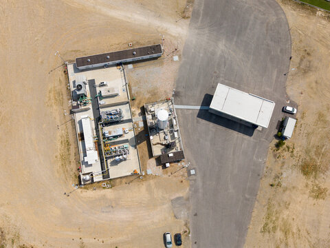 Aerial view of a modern biomethane production facility with bioCNG and bioLNG fueling station, featuring industrial equipment and storage tanks in Tavazzano con Villavesco, Lombardy, Italy.