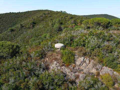 Aerial view of the historic bunker at Passo del Monumento surrounded by dense Mediterranean scrub and rocky terrain in Campo nell'Elba, Toscana, Italy.