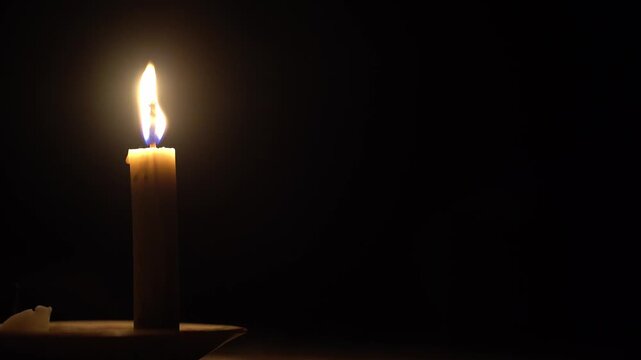 Single Candle Burning and Waving in the Dark with Copy Space