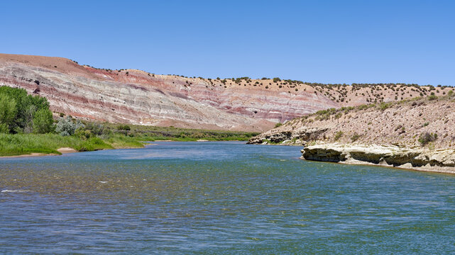 Panorama of the Green River flowing below painted hills at Dinosaur National Monument in Utah, USA