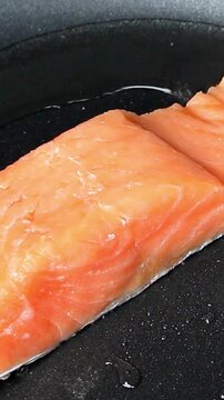Fresh salmon fillet searing in a hot frying pan